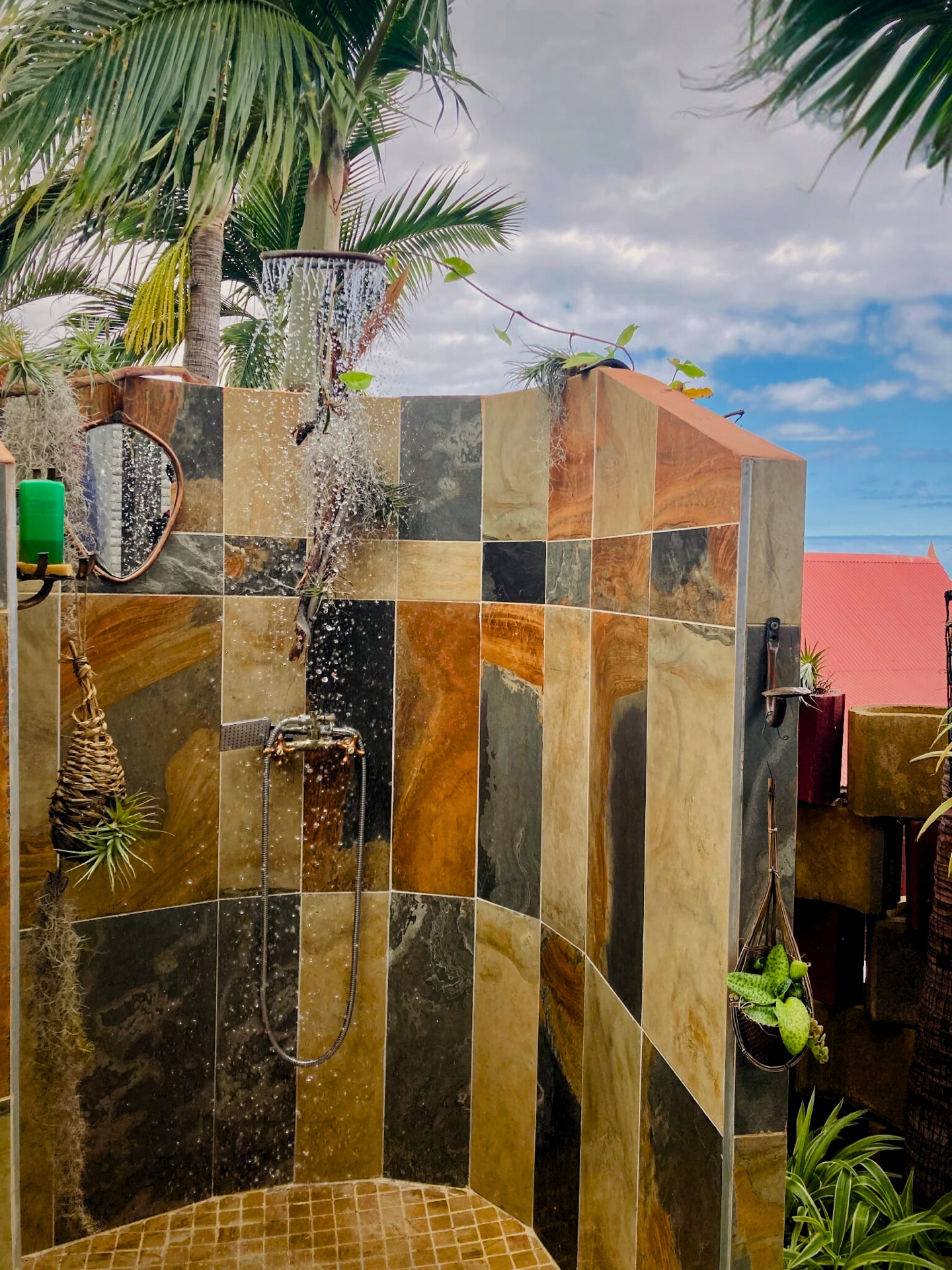 Douche extérieure en mosaïque au milieu de la végétation tropicale