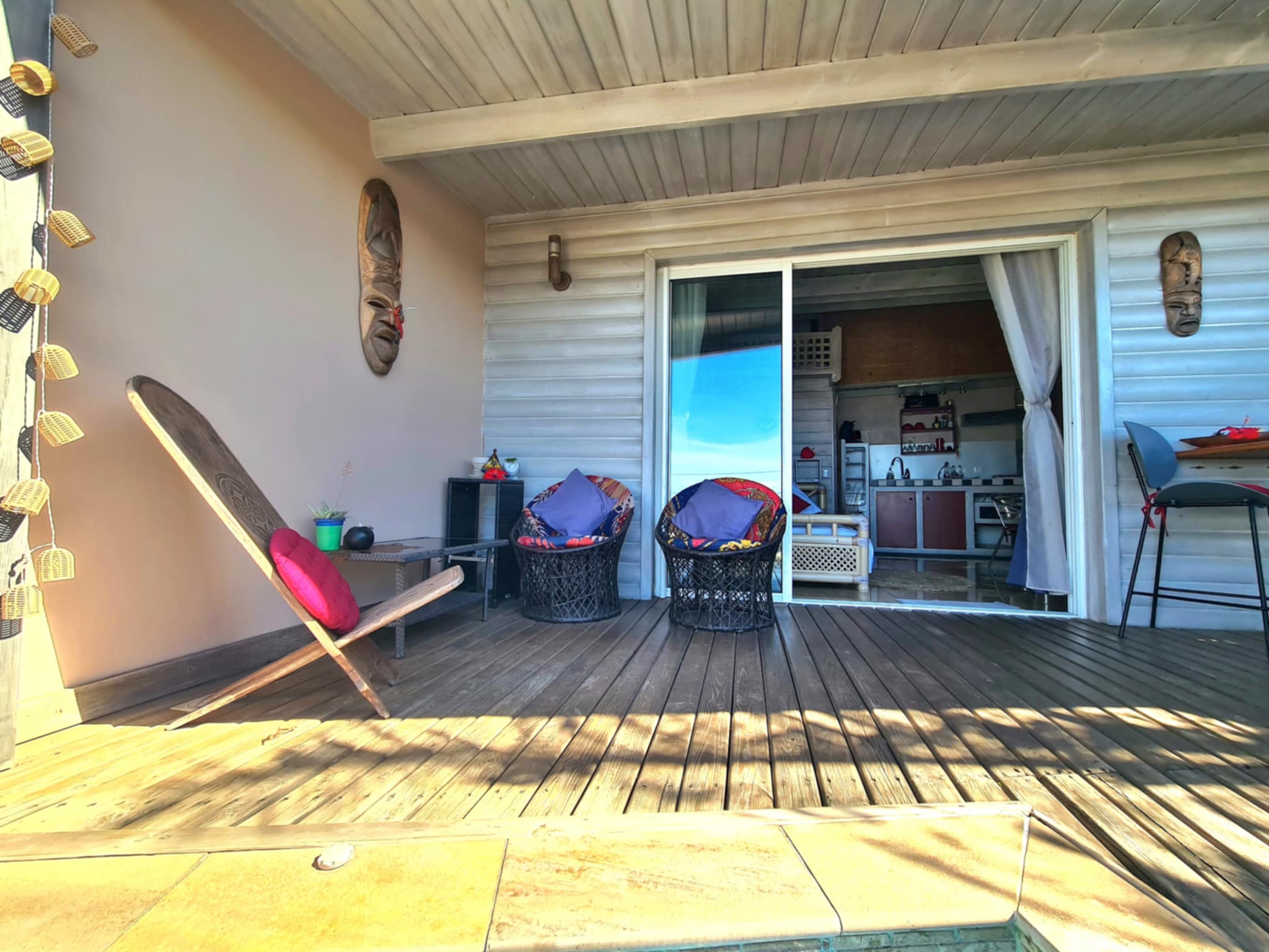 Terrasse en bois avec fauteuils et vue sur l'intérieur